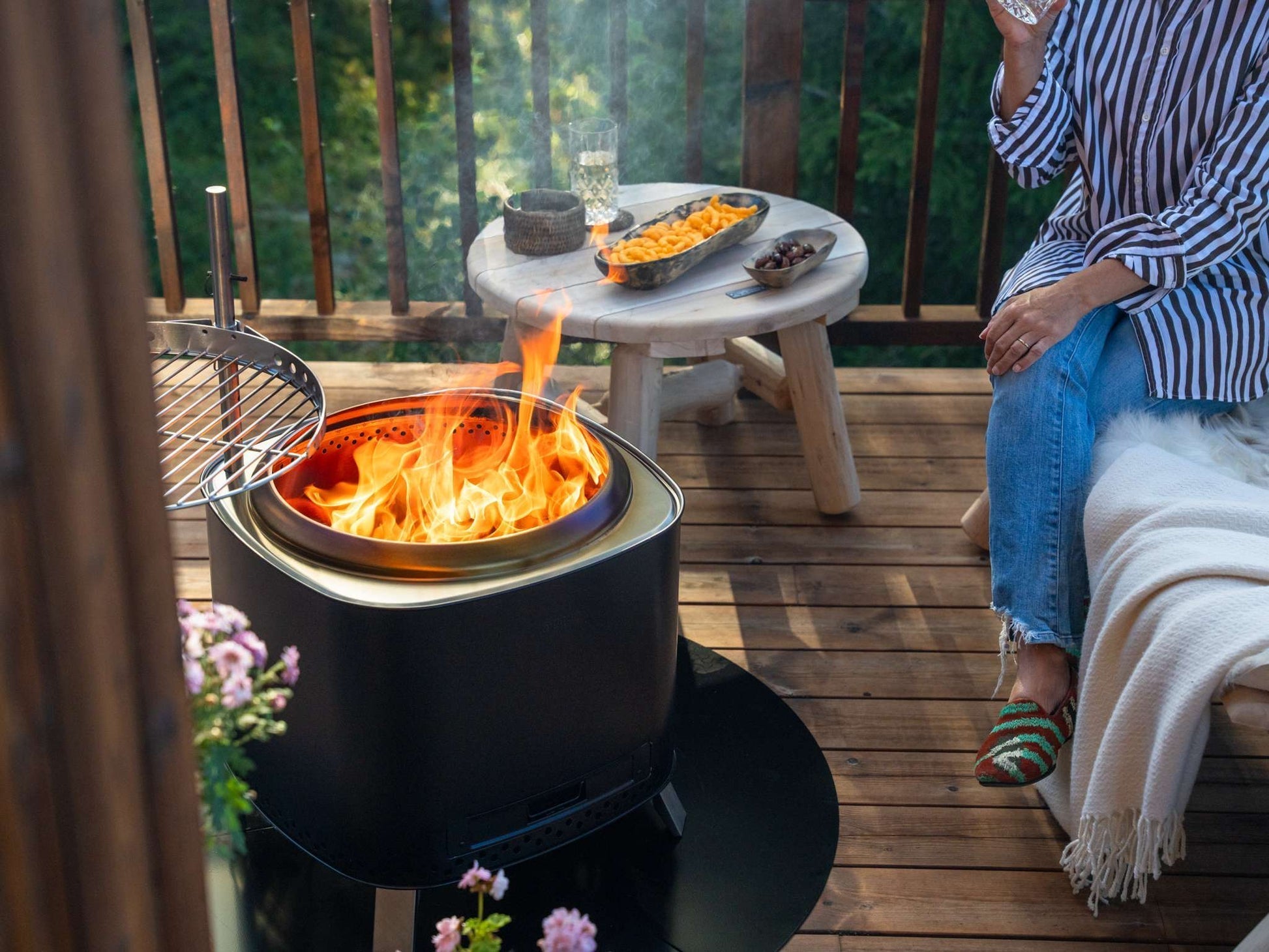 Espegard Brasa 50 rookvrije vuurkorf zwart op een klein houten terras met grillrooster