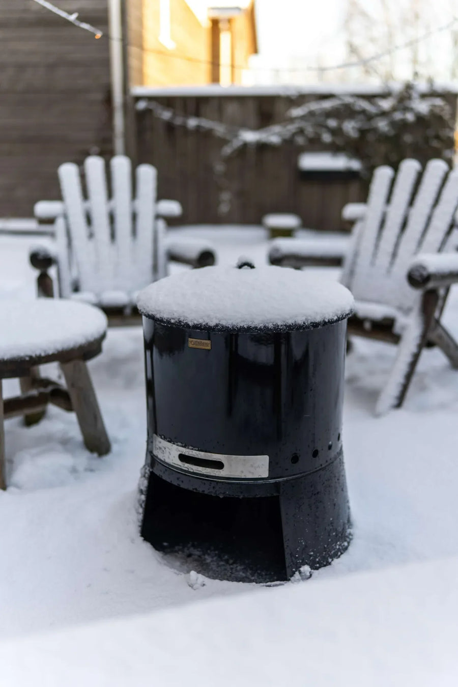 Espegard Pilar vuurkorf met deksel in een besneeuwde tuin