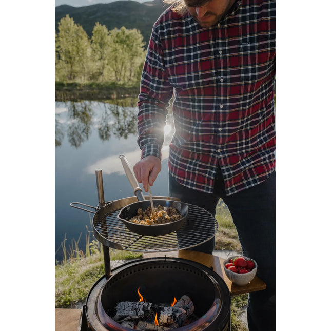 Koken in een gietijzeren pan op het grillrooster boven de Espegard Pilar vuurkorf