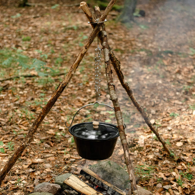 Driepoot van takken boven een kampvuur met de Espegard Driepoot Ring