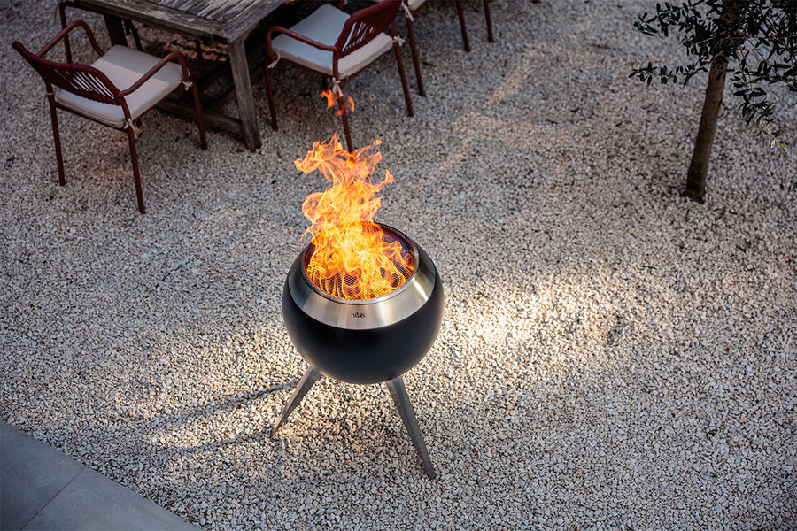 Brandende Höfats MOON 55 vuurkorf met vonkenvanger in de tuin