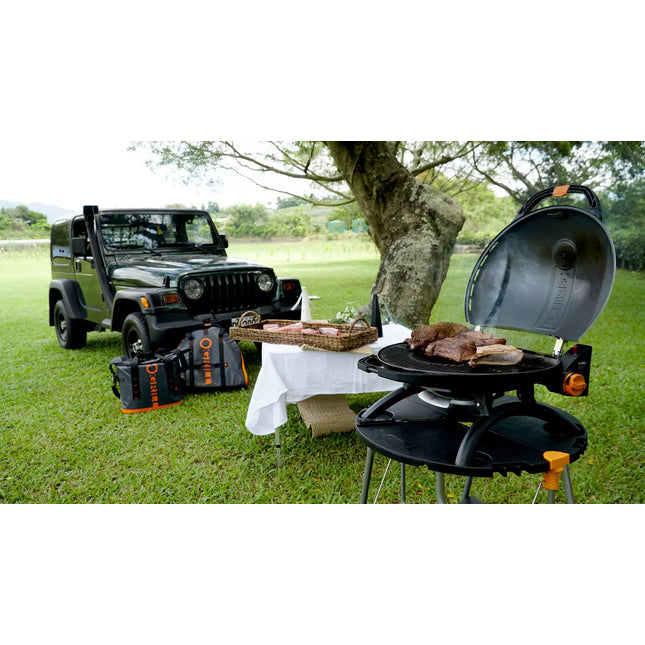 O-Grill 900 gasbarbecue op de O-Dock tafel tijdens een picknick in het groen
