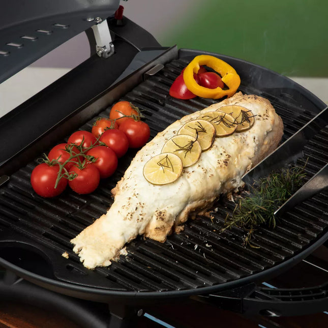 Hele vis met citroen en trostomaten op de grillplaat van de O-Grill gasbarbecue