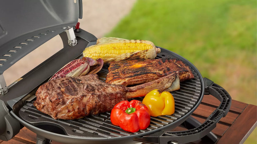Steak, spareribs en maïskolven op de geopende O-Grill 900 gasbarbecue