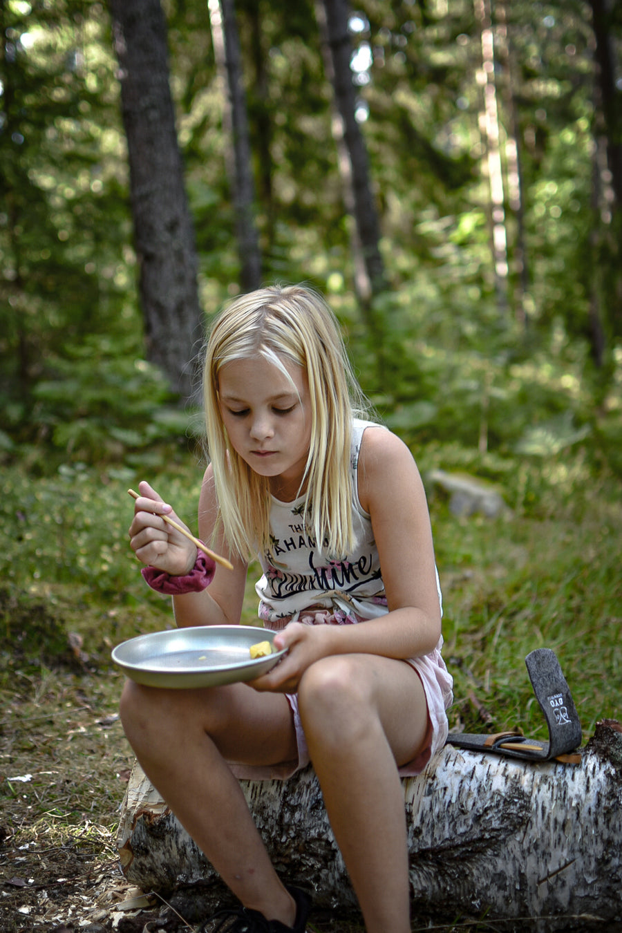 Meisje eet in het bos met het Øyo bamboe outdoor bestek
