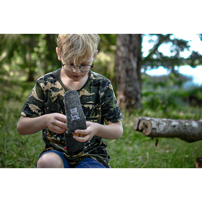 Jongen pakt het Øyo outdoor bestek uit de vilten etui in het bos