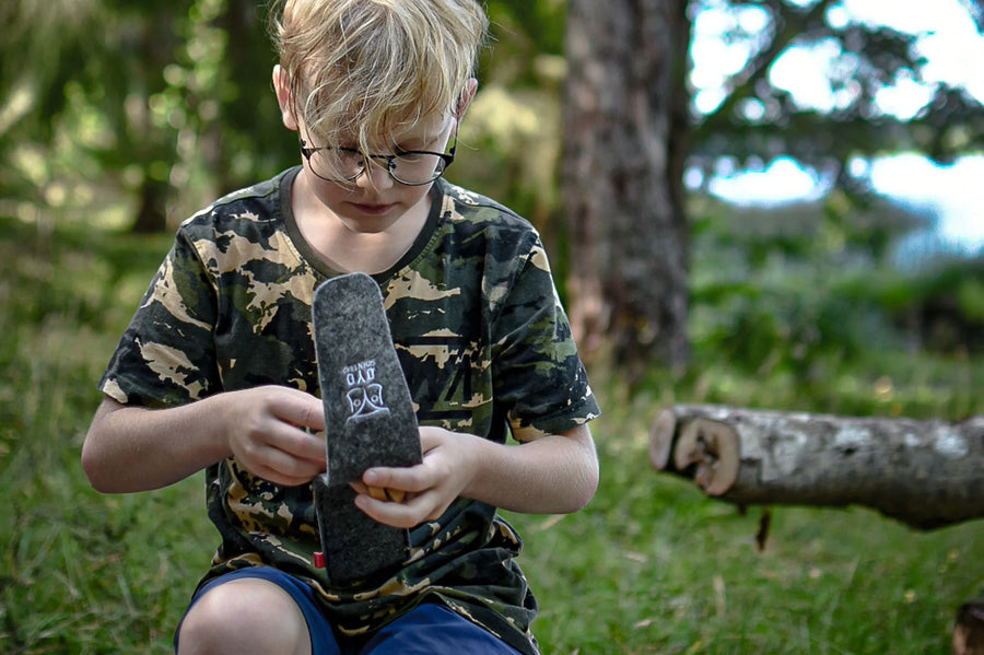 Jongen pakt het Øyo outdoor bestek uit de vilten etui in het bos
