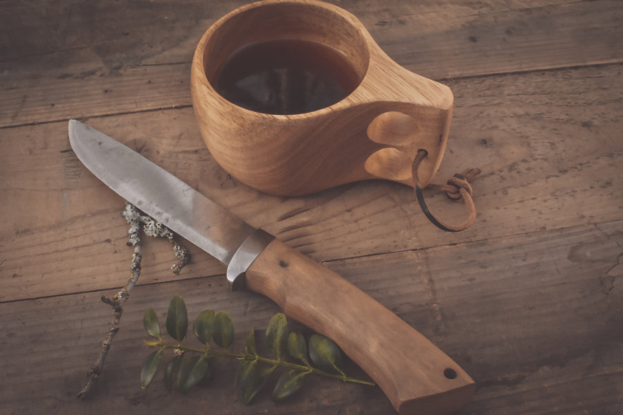 Øyo houten Sami mok met koffie op een houten tafel naast een Øyo jachtmes