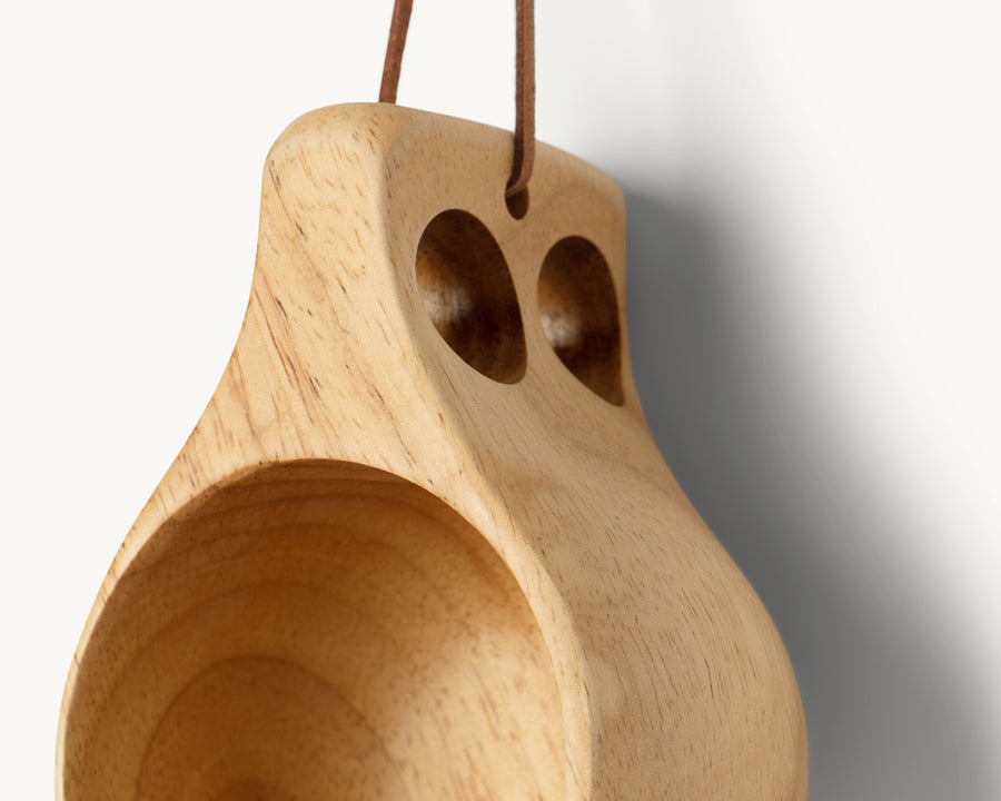 Close-up van de handgreep met twee vingergaten van de Øyo houten Sami mok