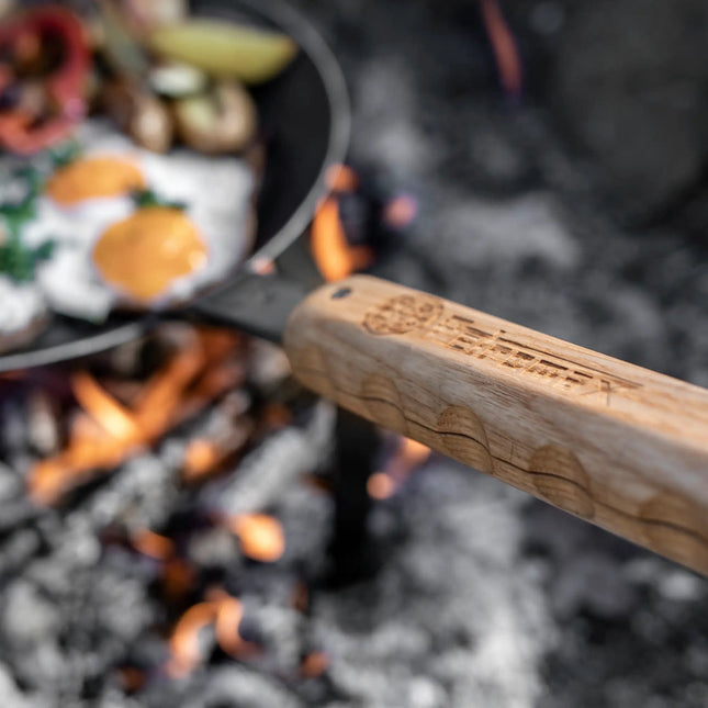 Petromax smeedijzeren pan met magnetische houten steel boven kampvuur