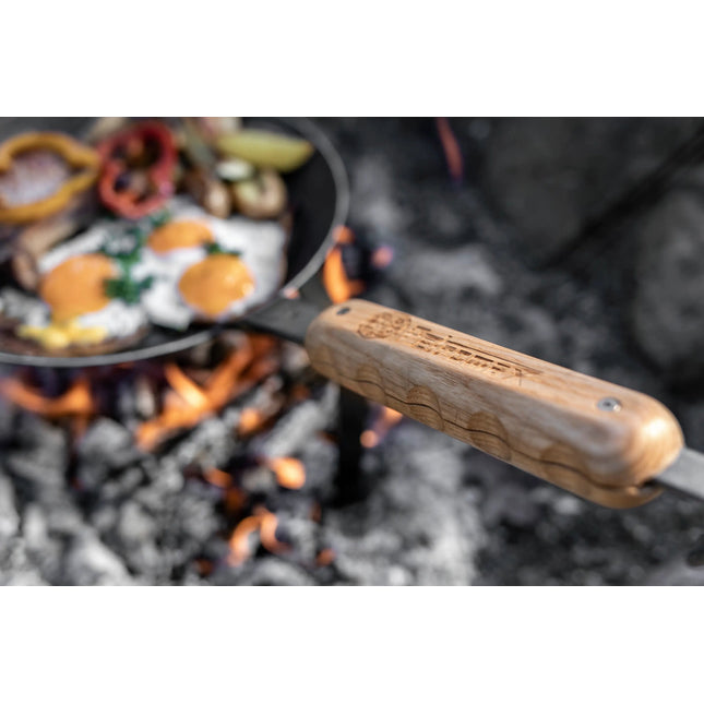 Petromax smeedijzeren pan met magnetische houten steel boven kampvuur